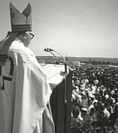 Kardinal Šeper s mitrom govori na mikrofon s oltara na otvorenom pred golemim mnoštvom.