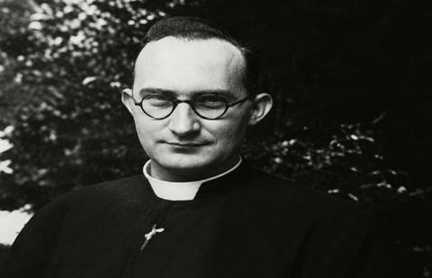 Franjo Šeper u svećeničkoj odjeći s okruglim naočalama, smiješi se, iza njega krošnje drveća.